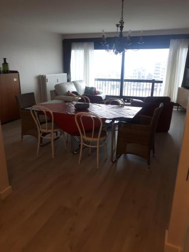 a living room with a table and chairs and a couch at Apartment Havenzicht in Blankenberge