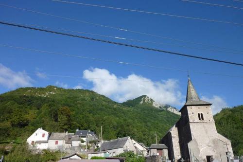 a church with a steeple in front of a mountain at Chalet Le Nordique Bain Nordique Sauna in Fréchet-Aure