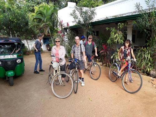 eine Gruppe von Menschen auf Fahrrädern vor einem Haus in der Unterkunft Goalma Family Holiday Resort & Restaurant in Anuradhapura