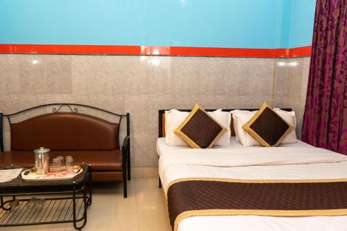 a hotel room with two beds and a table at Tirupati Lodge NJP in Siliguri