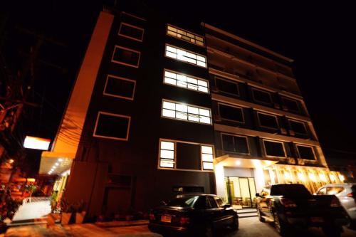 a tall building with lights in the windows at night at Windsor Hotel in Nakhon Phanom