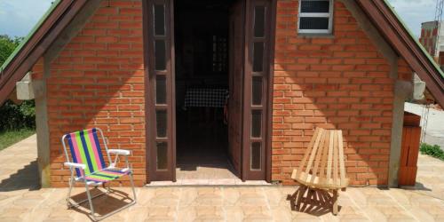 a brick house with a chair in front of a door at Cabaña AAA in Xuí