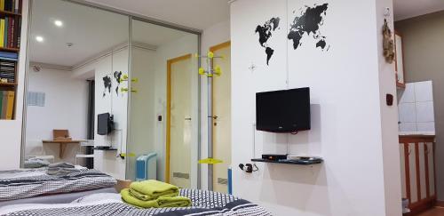 a room with a bed and a tv on a wall at Apartman i Studio apartman Majoli in Kukuljanovo