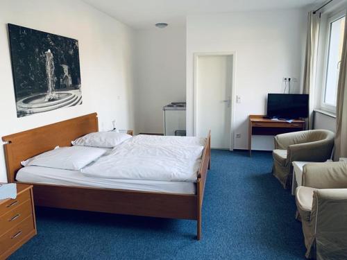 a bedroom with a bed and a desk and a chair at Gästehaus Bögemann in Bad Rothenfelde