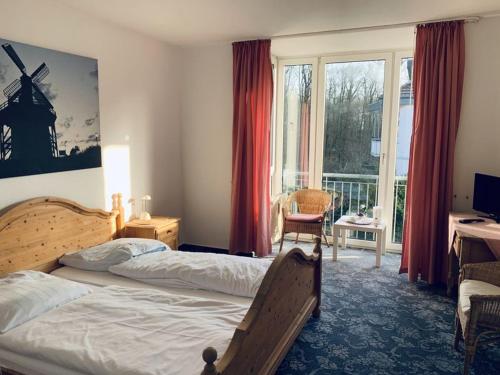 Schlafzimmer mit einem Bett, einem Schreibtisch und einem Fenster in der Unterkunft Gästehaus Bögemann in Bad Rothenfelde