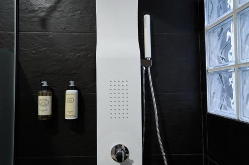 a black bathroom with two bottles of alcohol in a shower at Downtown Loulé in Loulé