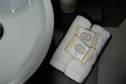 two boxes of soap sitting on towels next to a toilet at Downtown Loulé in Loulé