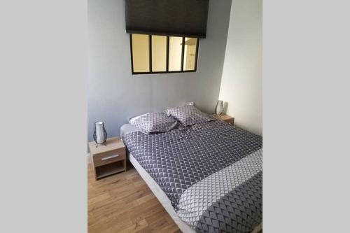 een kleine slaapkamer met een bed en een raam bij Le petit Beure in Beure