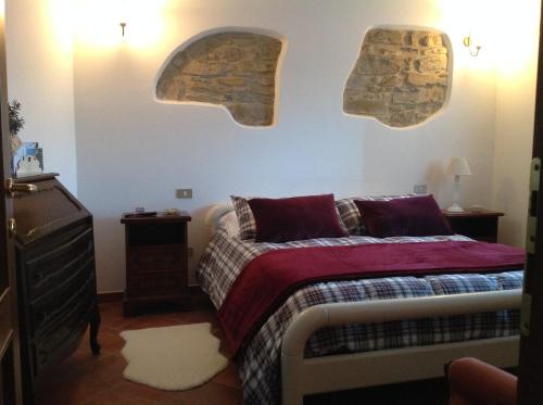 a bedroom with a bed and a wall with two archs at Il Piccolo Giardino in Perinaldo