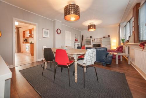 a dining room and living room with a table and chairs at Apartmenthaus Lorbach in Solingen