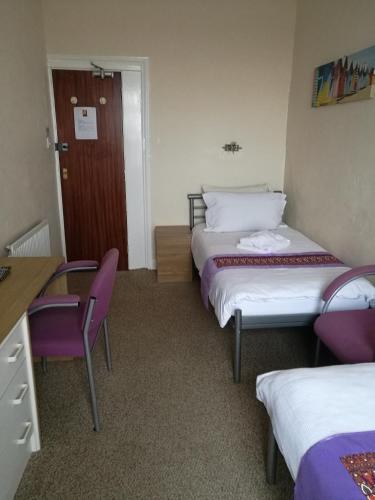 a hotel room with two beds and a table and chairs at Westleigh in Morecambe