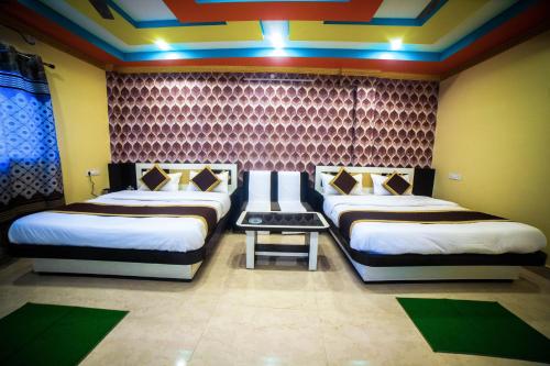 a room with two beds in a room at Tirupati Lodge NJP in Siliguri