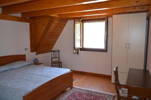 サンタンティーオコにあるCasa Vacanze Cala Saponeのベッドルーム1室(ベッド1台、窓、テーブル付)