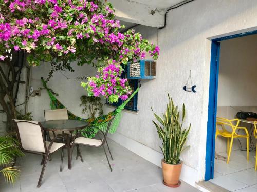 un patio con mesa, sillas y flores en Lindo Apartamento em Arraial, en Arraial do Cabo