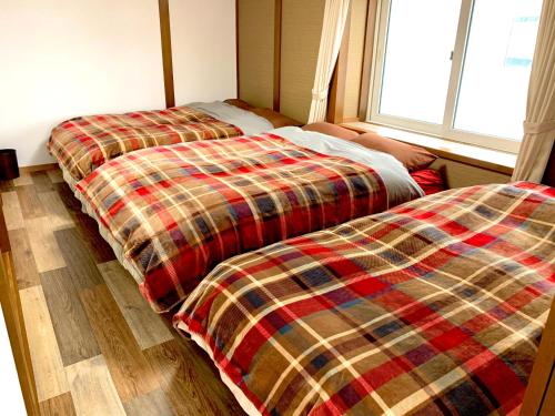 two beds sitting next to each other in a room at Pokke 白老駅徒歩4分 in Shiraoi