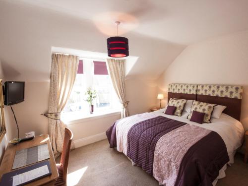 a bedroom with a bed and a window at The Ness Guest House in Inverness