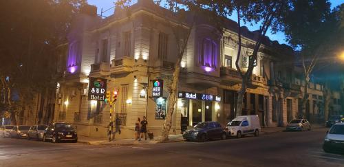 un edificio en una calle con coches aparcados delante en Sur Hotel, en Montevideo