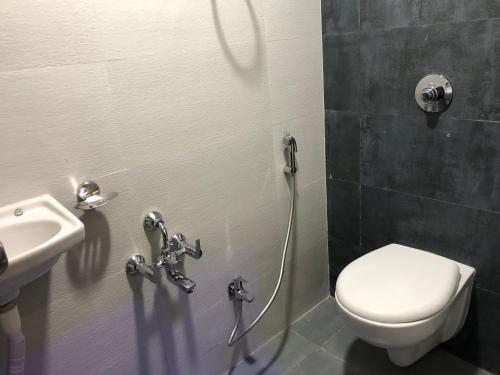 een badkamer met een toilet en een wastafel bij ELLIOTT INN A.C DORMITORY in Mumbai