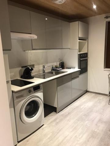 a kitchen with a washing machine and a sink at Studio Brides les bains in Brides-les-Bains