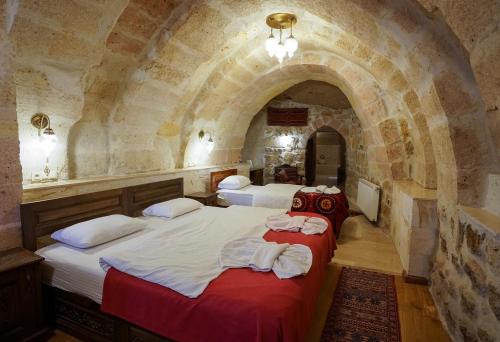 a bedroom with two beds in a stone room at Yoruk Stone House in Nevsehir