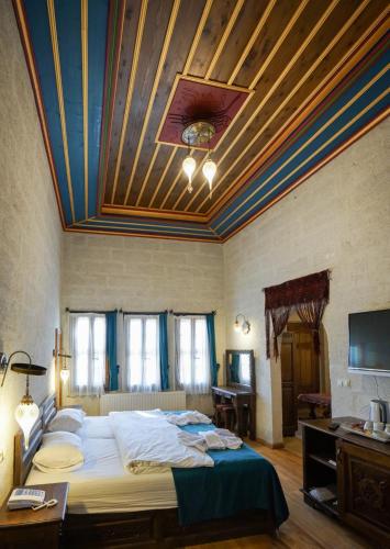 a bedroom with a large bed with a wooden ceiling at Yoruk Stone House in Nevsehir