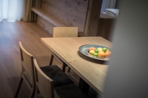 a plate of fruit on a wooden table at Residence Margareth in Campo Tures