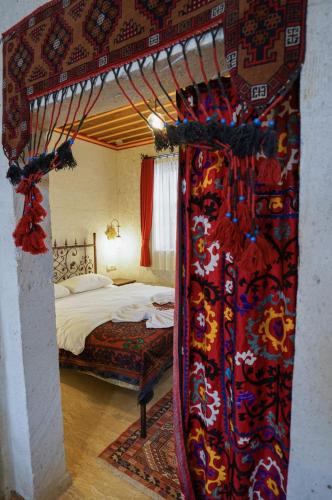 a bedroom with a bed and a curtain in a room at Yoruk Stone House in Nevsehir