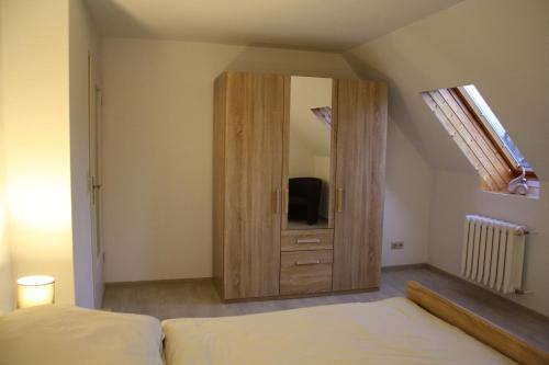 a bedroom with a large wooden cabinet with a television at Ferienwohnung im Harz in Wienrode