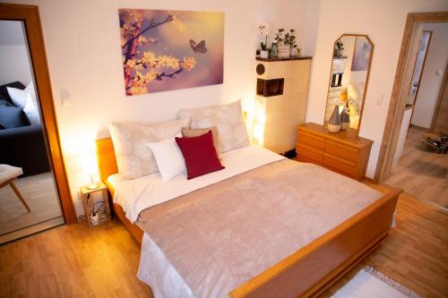 1 dormitorio con 1 cama grande y espejo en Apartments Marie A en Hallstatt