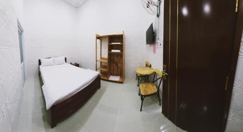 a small room with a bed and a chair at The Sun Hotel in Tây Ninh