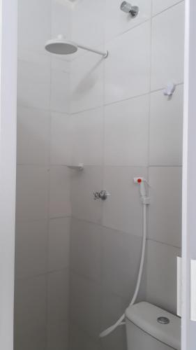 a white bathroom with a shower and a toilet at Suíte zona Sul de ilhéus próximo a praia in Ilhéus