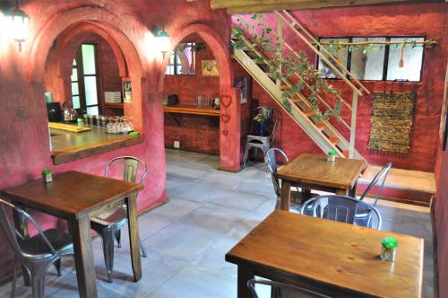 a restaurant with wooden tables and chairs and a staircase at Flamboyant Guesthouse in Bela-Bela
