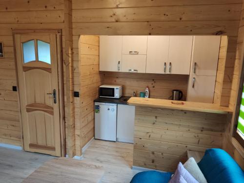 a small kitchen in a log cabin with a refrigerator at Ostoja Rodzinna in Giżycko