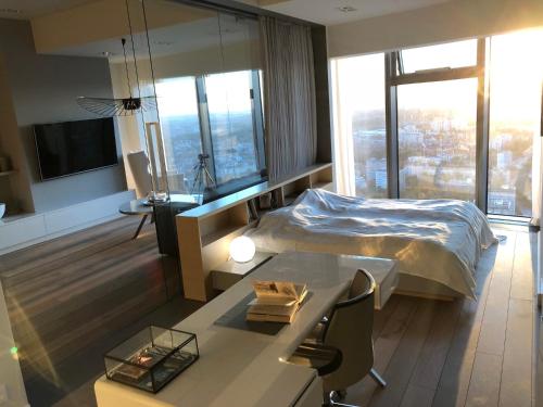 a hotel room with a bed and a desk and a table at Vantage Point Apartament Sky Tower in Wrocław