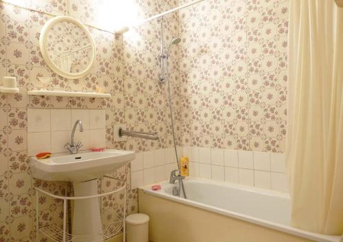 La salle de bains est pourvue d'un lavabo et d'une baignoire. dans l'établissement Gîte rural La Bergerie du Sant, à Massaguel