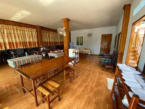 uma sala de estar com uma mesa de madeira e cadeiras em Baan Kokaew Chiang Khan em Chiang Khan