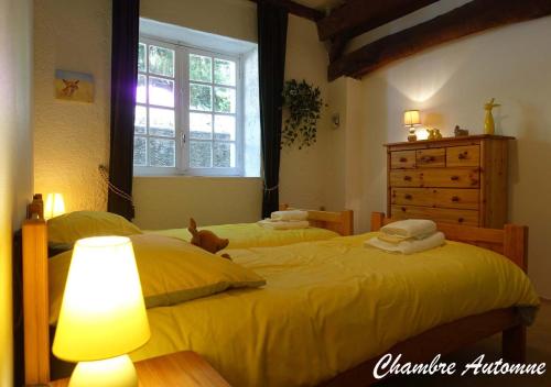 - une chambre avec 2 lits avec des draps jaunes et une commode dans l'établissement Gîte rural La Bergerie du Sant, à Massaguel