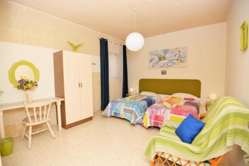 1 dormitorio con 2 camas individuales y escritorio en Avalon - Bellevue Gozo, en Xlendi