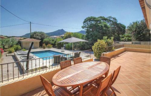 un patio avec une table et des chaises et une piscine dans l'établissement Cozy Home In Algajola With Wifi, à Algajola