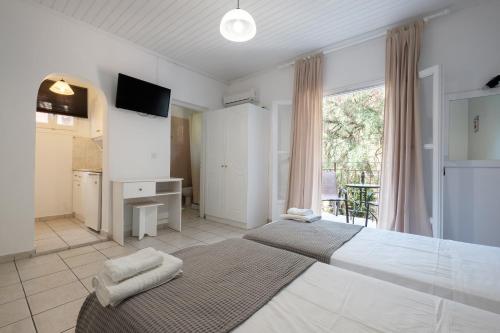 a bedroom with a large bed and a kitchen at Stavroula Studios in Paleokastritsa