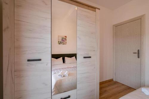 a bedroom with a glass door leading to a bed at Vasic Apartments in Herceg-Novi