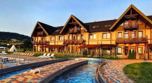 a large building with a pool in front of it at Luxury Apartment in Bešeňová