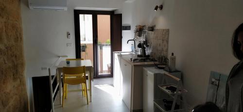 een keuken met 2 gele stoelen en een fornuis bij La Nicuzza-#historicalhouse in Agrigento