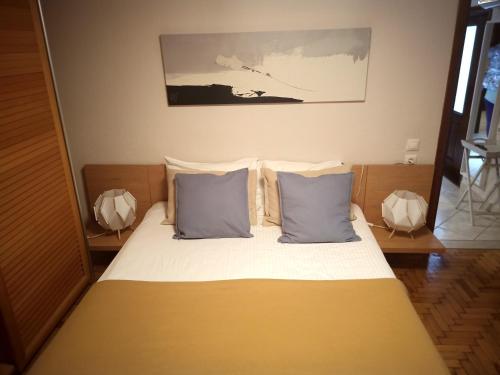 sypialnia z łóżkiem z 2 niebieskimi poduszkami w obiekcie Plateia Apartments (Katerina) w mieście Ajos Nikolaos