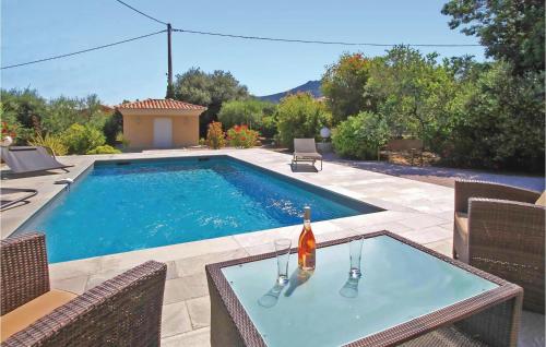a swimming pool with a table and a bottle of wine at Cozy Home In Algajola With Wifi in Algajola