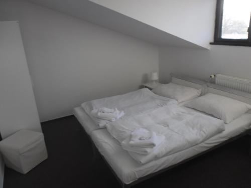 a white bed with towels on it in a room at bike-Hotel Měděnec in Nové Město pod Smrkem