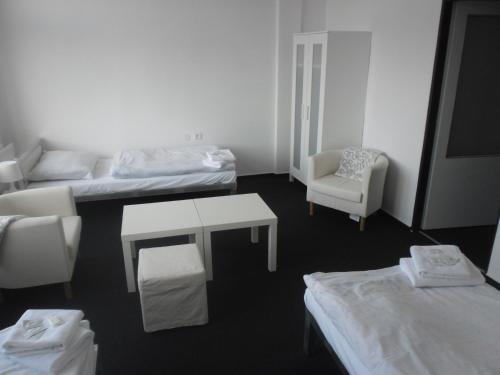 Habitación con 2 camas, mesa y silla en bike-Hotel Měděnec, en Nové Město pod Smrkem