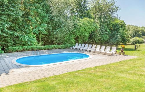 a small swimming pool with chairs and a table at Nice Home In Simpelveld With Wifi in Simpelveld