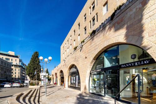 a brick building on a city street with a store at King David 19 Apartment in Jerusalem