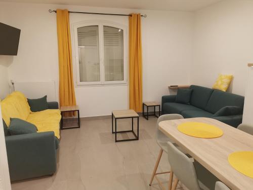 a living room with two couches and a table at Les pieds dans l'eau in Trouville-sur-Mer